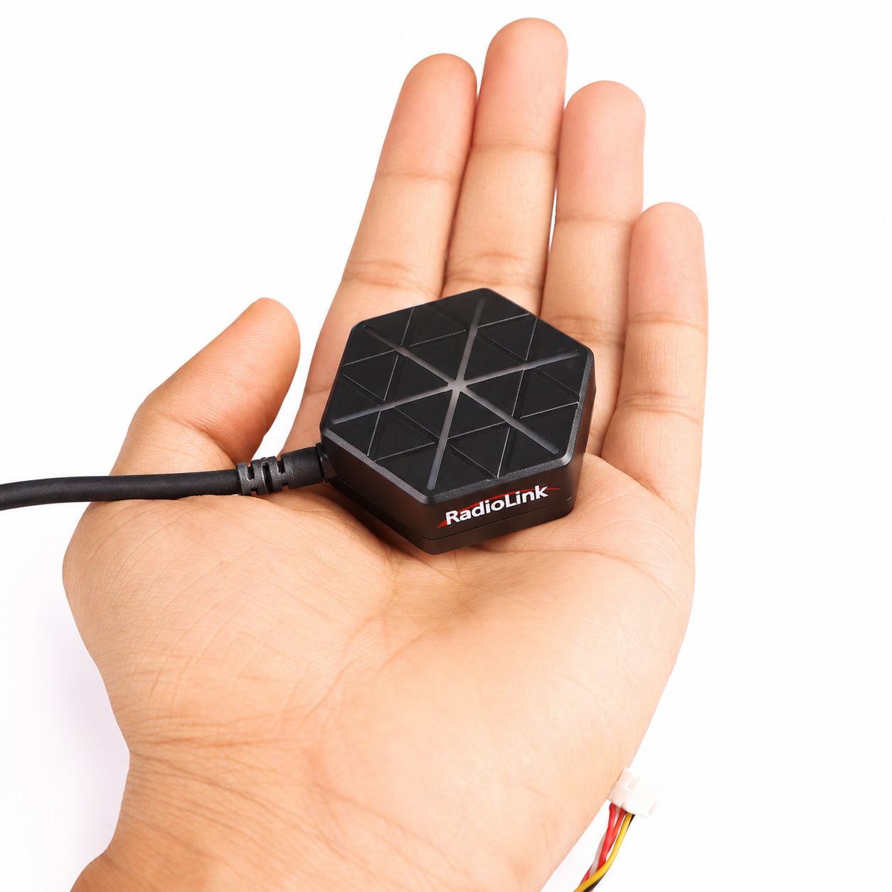 Radiolink SE100 GPS module shown in hand for size comparison