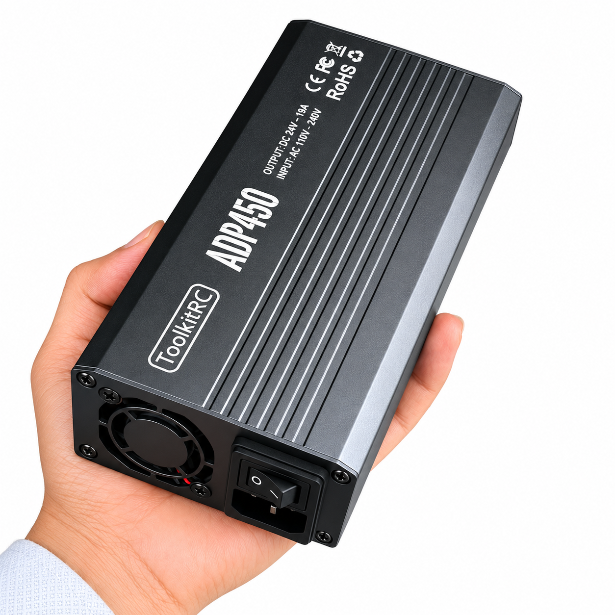 ToolkitRC ADP450 power supply shown in hand for size comparison
